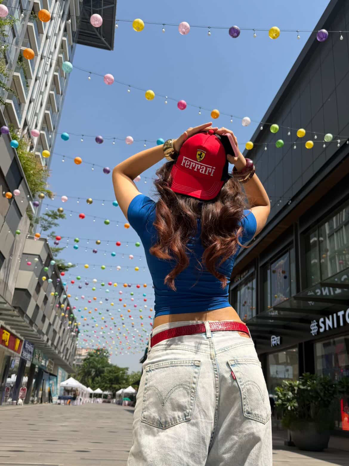 Model wearing the red CROSS Ferrari trucker cap on a city street at night